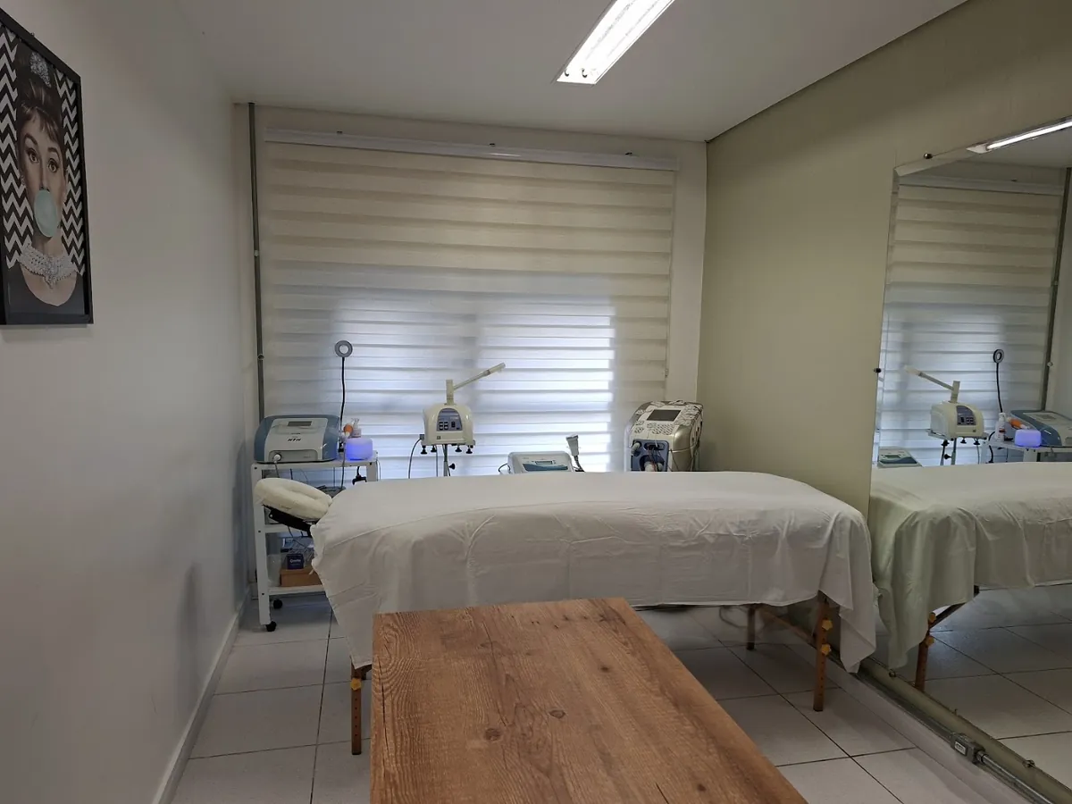 Sala de atendimento de Marta Rocha, com maca e equipamentos de estética